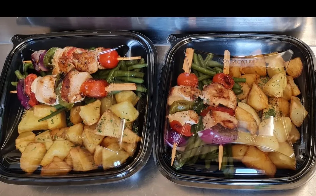 Deux plateaux repas avec légumes et brochettes